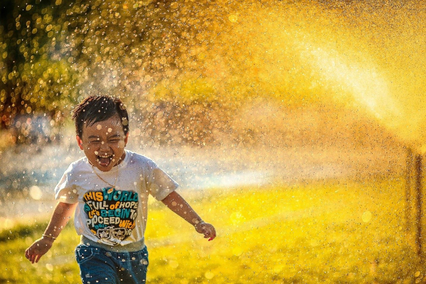 Child Playing in Sprinkler